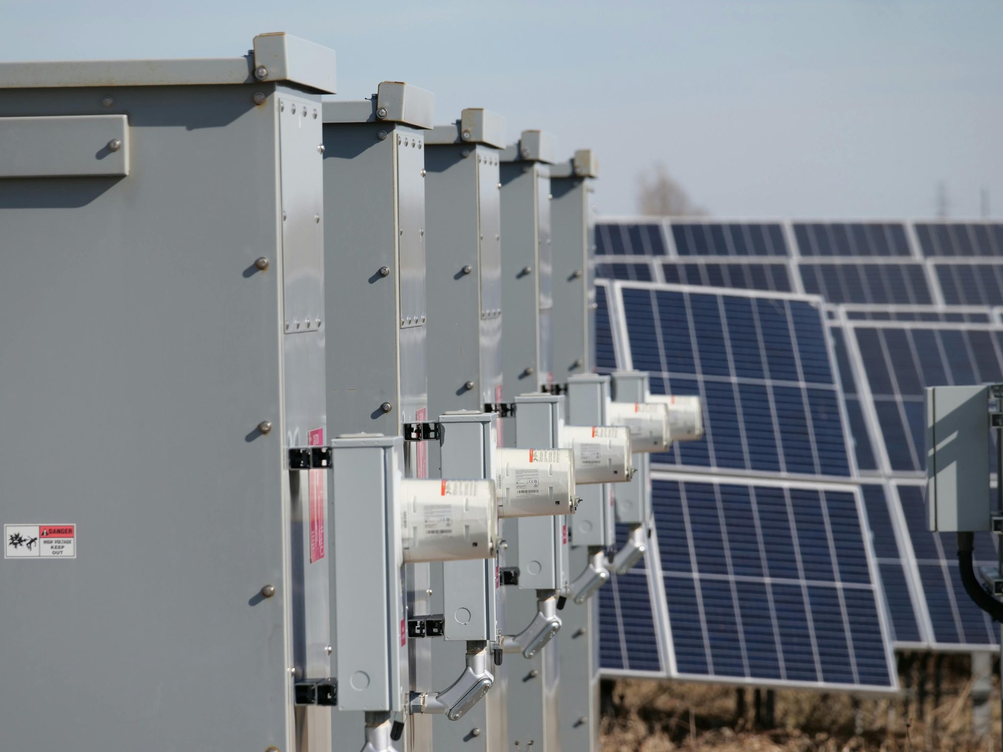Close-up of electrical boxes and solar panels harnessing solar energy outdoors.